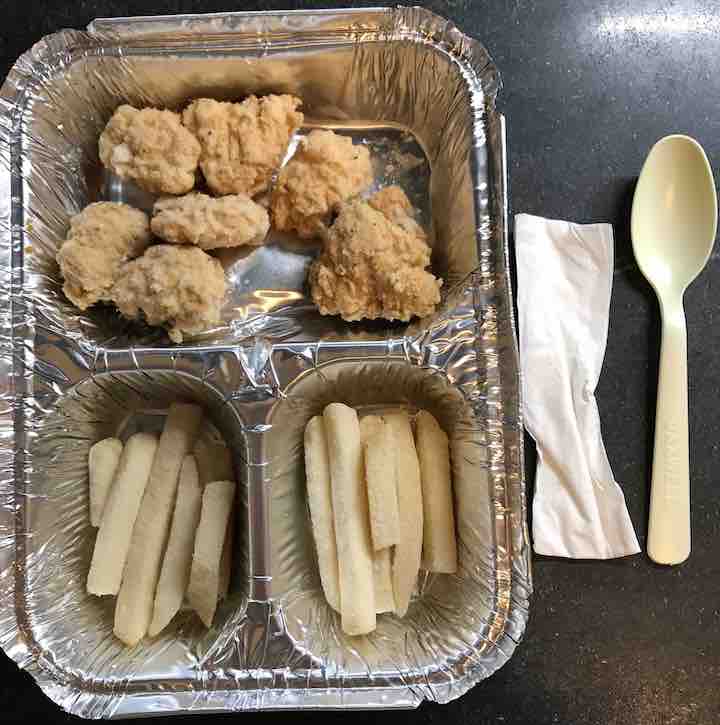 aluminum tray with breaded chicken balls in the half-size pocket and french fries in both quarter-size pockets